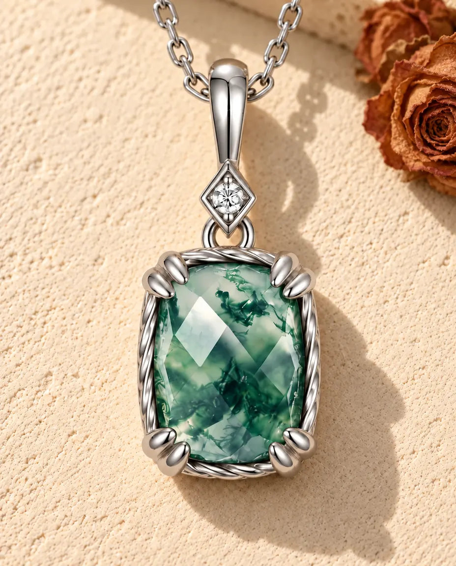 Moss Agate Pendant Necklace in 925 Sterling Silver - lying on a cream textured surface beside a travertine block