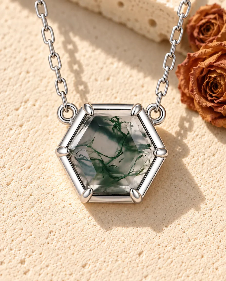 Hexagon Moss Agate Necklace in 925 Sterling Silver - lying on a cream textured surface beside a travertine block