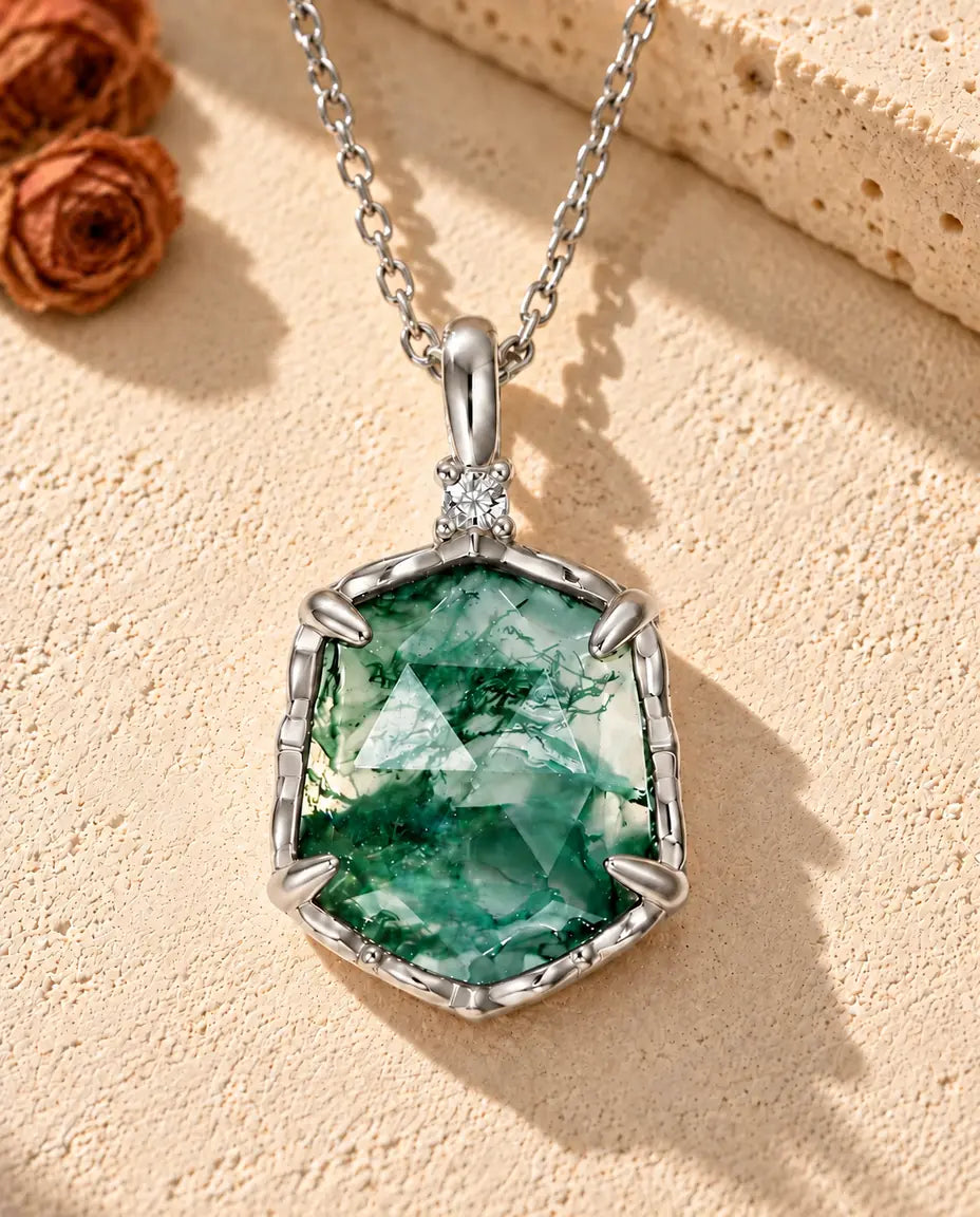 Hexagon Moss Agate Necklace in 925 Sterling Silver - lying on a cream textured surface beside a travertine block
