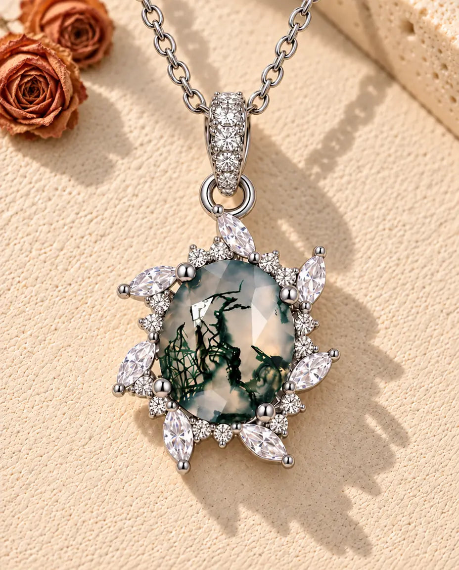 Moss Agate Starburst Necklace in 925 Sterling Silver - lying on a cream textured surface beside a travertine block
