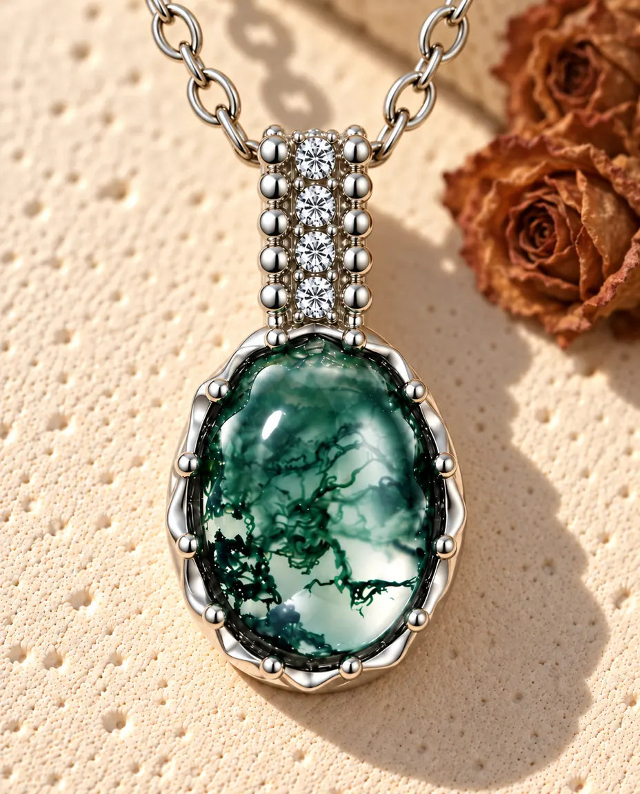 Oval Moss Agate Necklace in 925 Sterling Silver - lying on a cream textured surface beside a travertine block