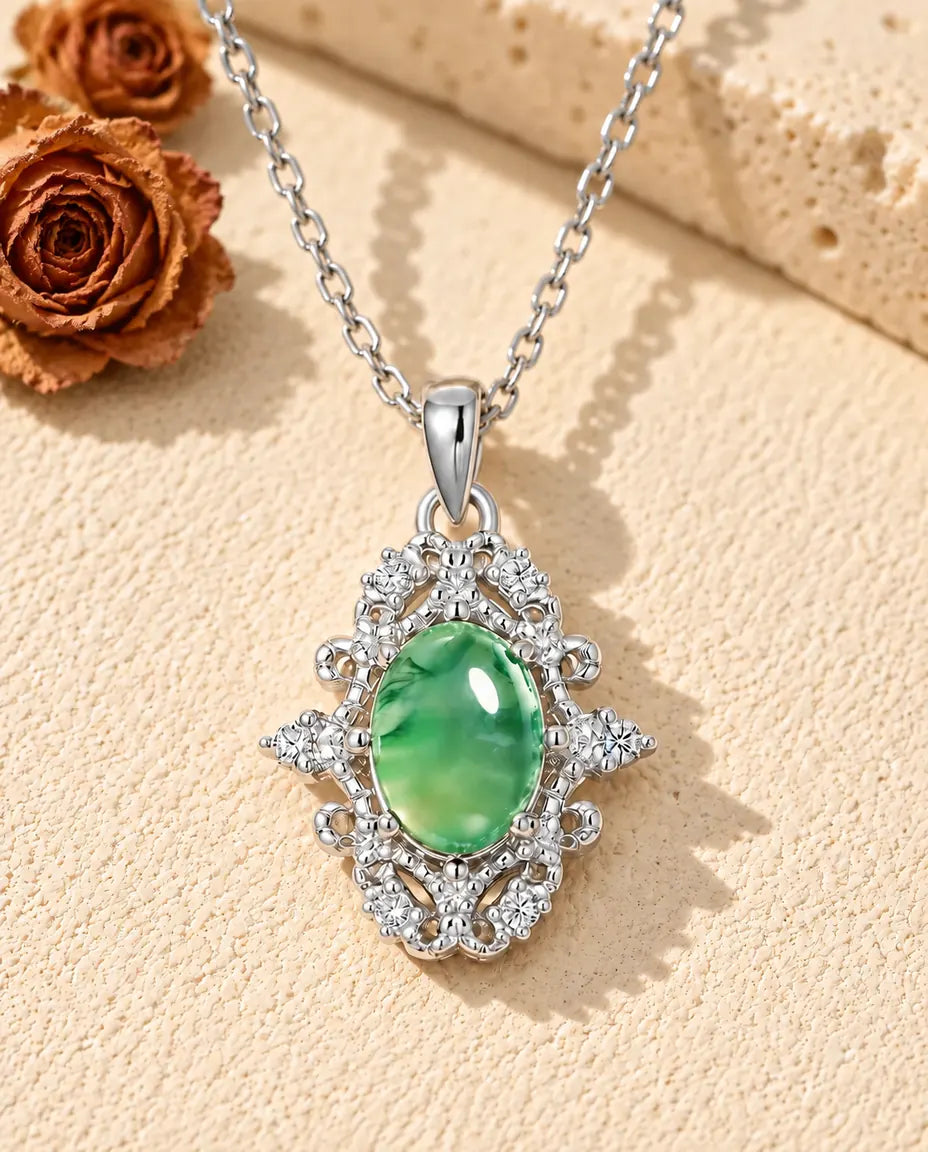 Oval Moss Agate Lace Necklace in 925 Sterling Silver - lying on a cream textured surface beside a travertine block