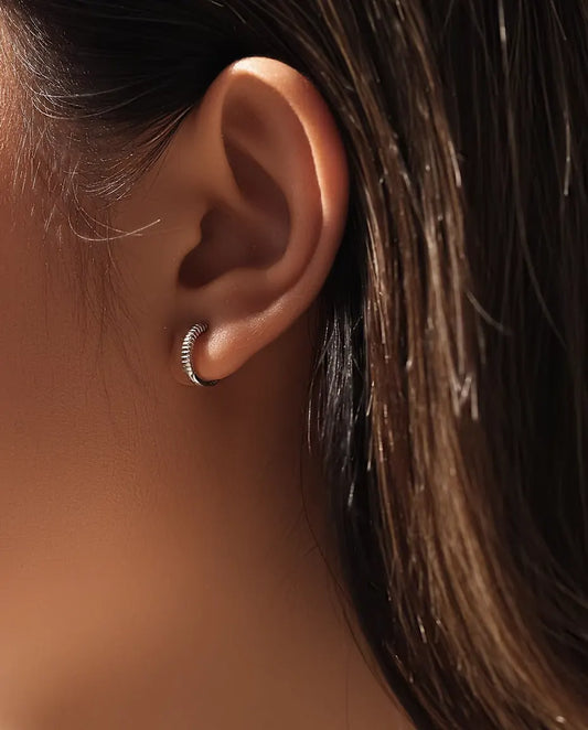 Ribbed Huggie Hoop Earrings in 925 Sterling Silver - worn on a model’s ear, close-up