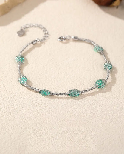 Caged Zircon Bracelet in 925 Sterling Silver - laid flat on a cream textured surface with the clasp and extender