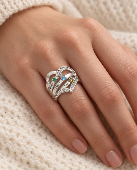 woman wearing personalised heart birthstone ring with 3 engraved names on her ring finger
