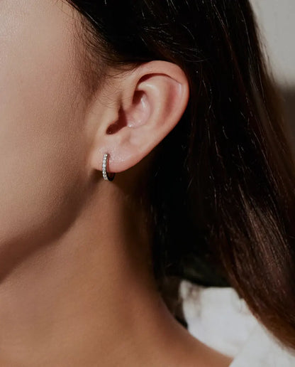 Moissanite Huggie Hoop Earrings in 925 Sterling Silver - worn on a model’s ear, side profile