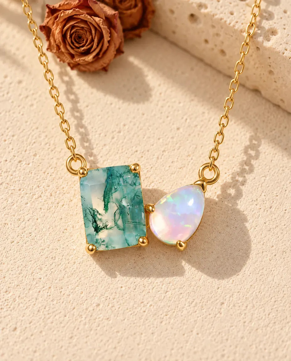 Moss Agate and Opal Necklace in 10K Gold Plated 925 Sterling Silver - lying on a cream textured surface beside a travertine block