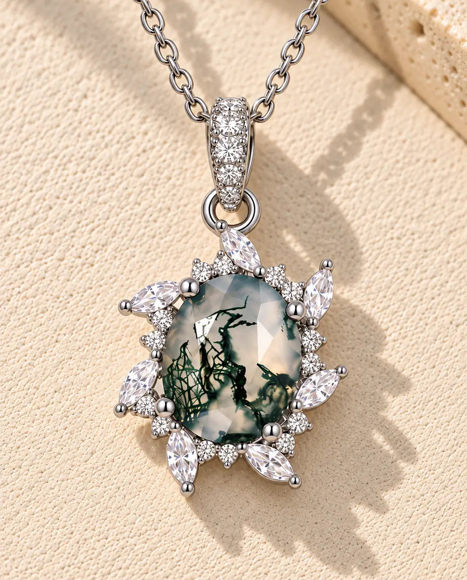 Moss Agate Starburst Necklace in 925 Sterling Silver - lying on a cream textured surface beside a travertine block