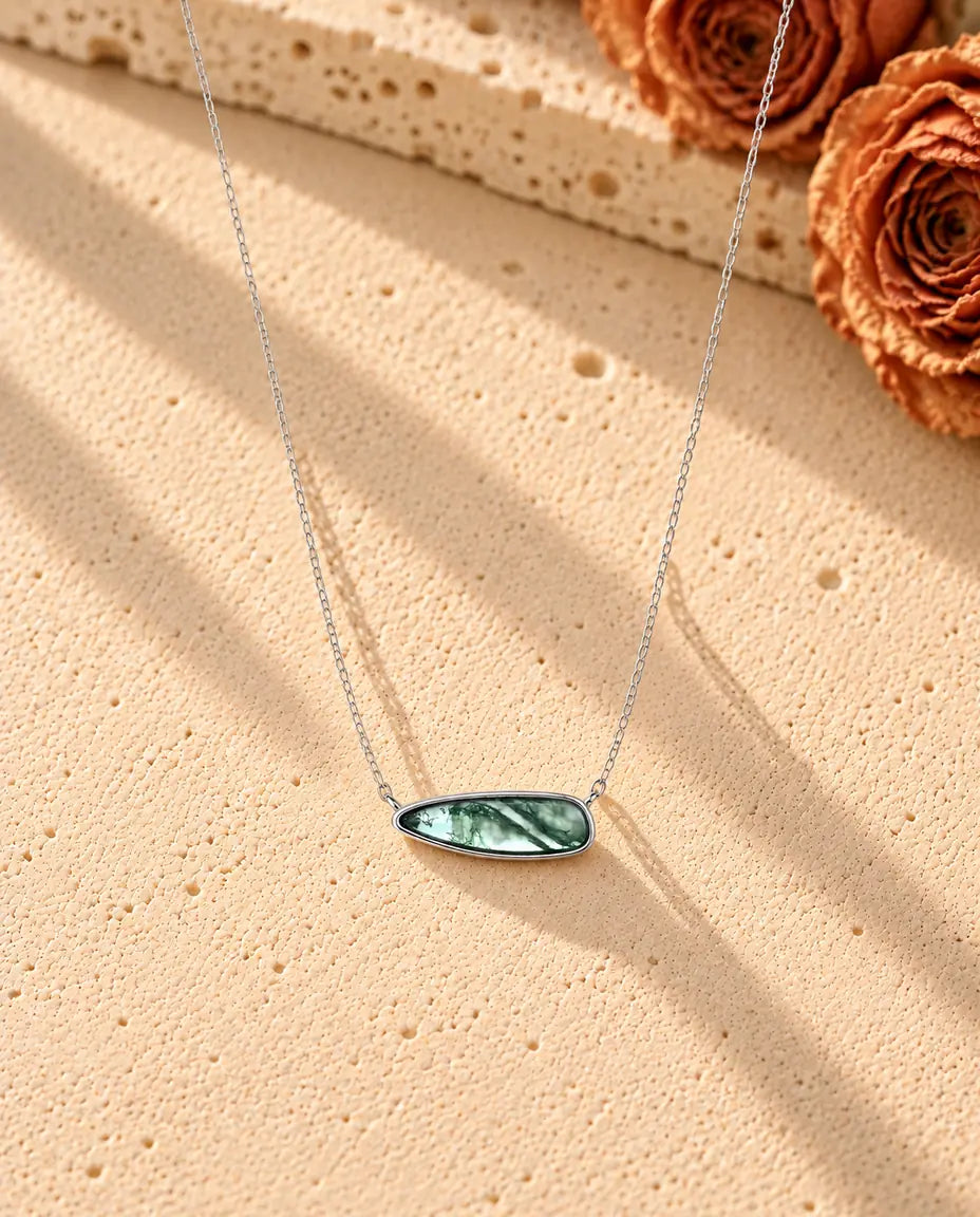 Moss Agate Bar Necklace in 925 Sterling Silver - the whole necklace laid out in a long V on a cream textured surface