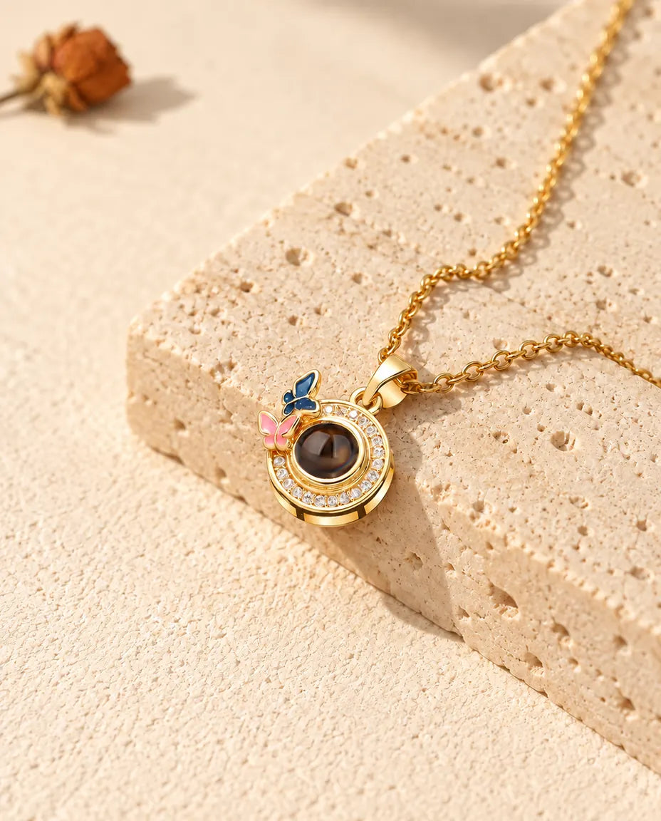 Gold tone butterfly circle projection necklace on a travertine block in warm sunlight