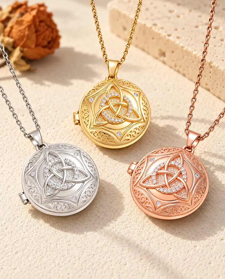 Three colours of the Celtic knot photo locket necklace arranged on plaster