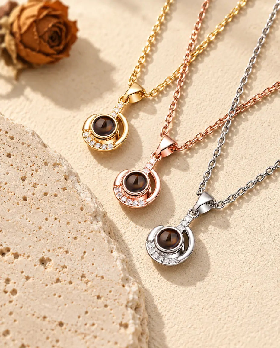 Three crescent moon necklaces laid diagonally with cubic zirconia