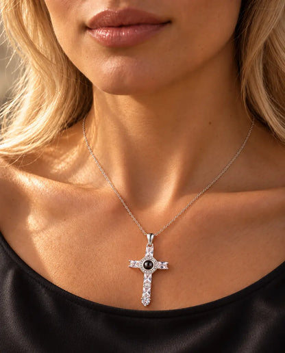 Woman in a black top wearing the silver tone cubic zirconia cross projection necklace