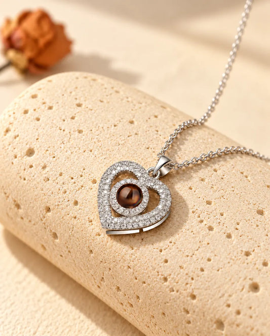 Personalised double heart photo projection necklace in silver tone with pave cubic zirconia, on a travertine block