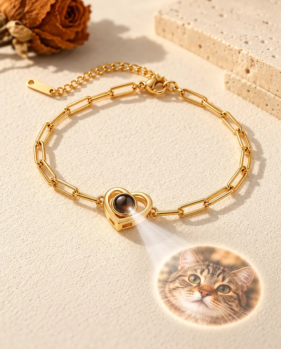 Light through the brown stone of the gold tone double heart bracelet projects a round photo onto the plaster