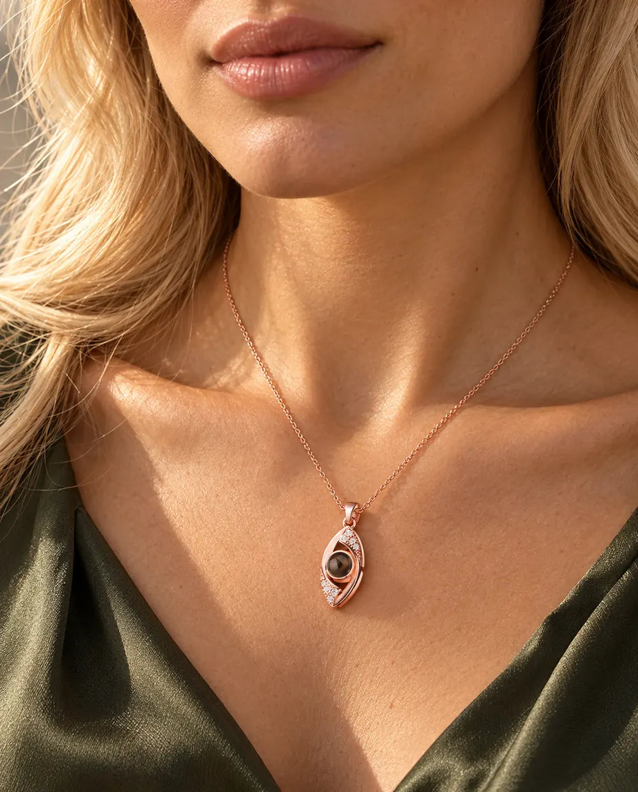 Woman in an olive green top wearing the rose gold tone evil eye projection necklace