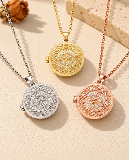Three colours of the four-loop Celtic knot photo locket necklace arranged on plaster