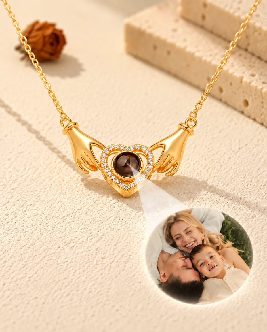 Light projected through the brown bead of the gold hands holding heart necklace showing a family photo