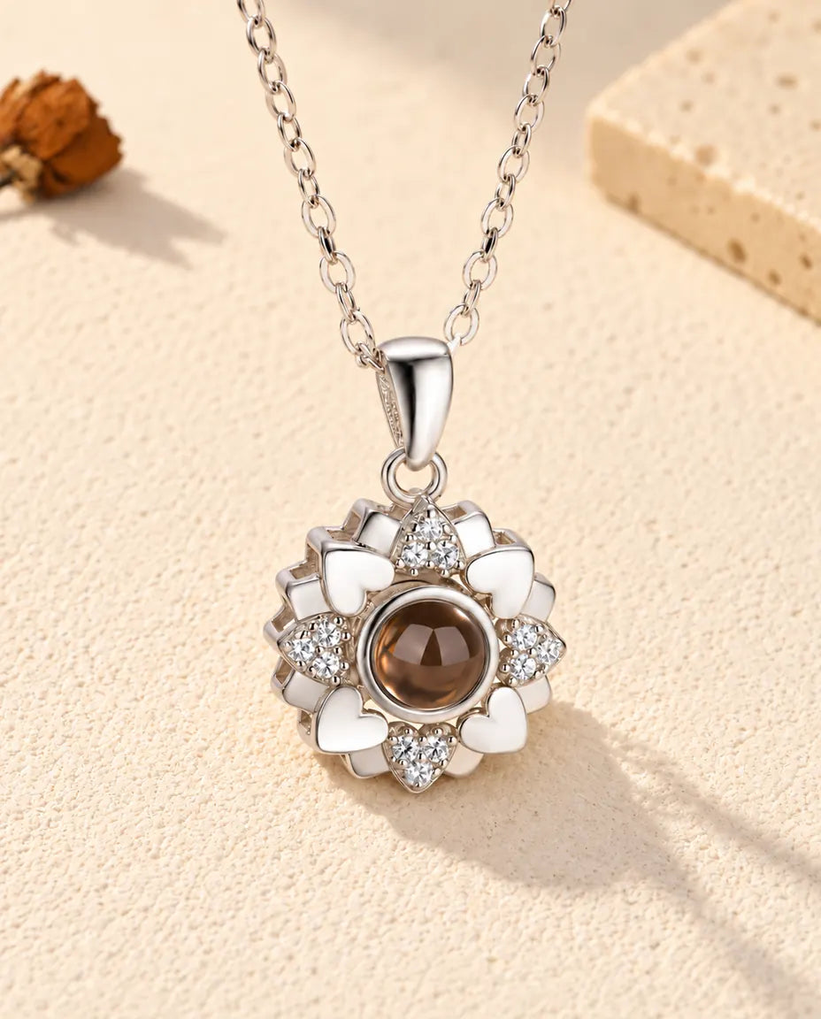 Front view of the silver tone heart flower projection necklace