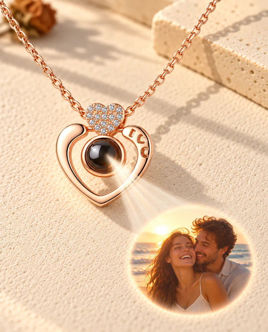 Rose gold tone open heart necklace projecting a beach couple photo onto cream plaster