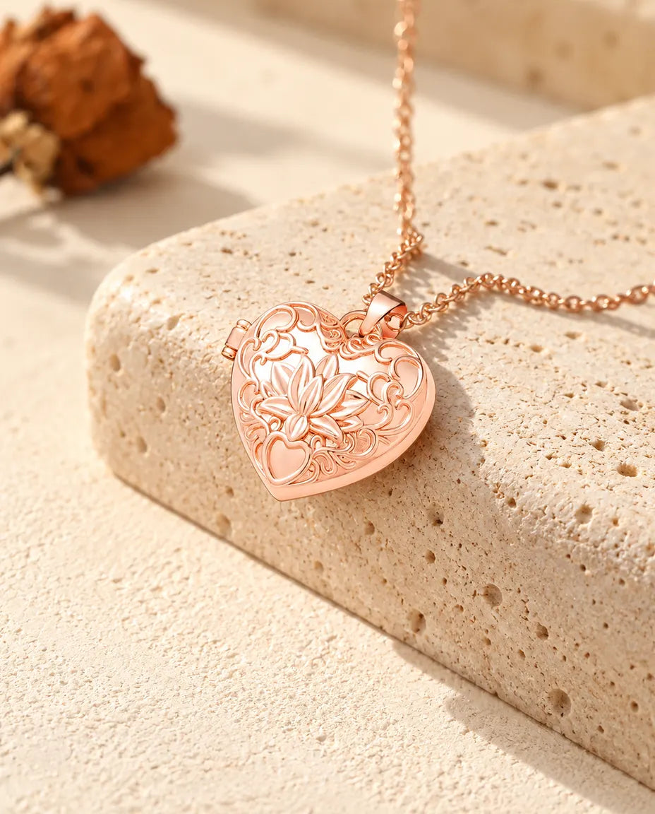 Rose gold tone lotus flower heart photo locket necklace on travertine in warm sunlight