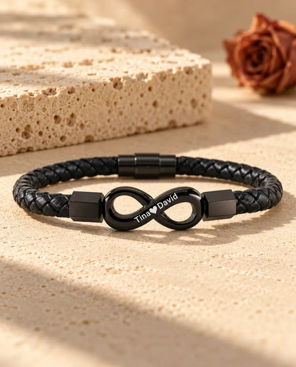 Personalised men's infinity bracelet in black on a braided faux leather cord, engraved with two names and a heart