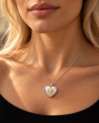 Woman in a black knit top wearing the silver tone north star heart photo locket necklace