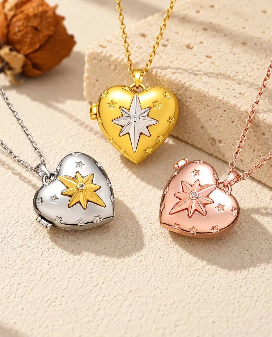 Three colours of the north star heart photo locket necklace arranged on plaster