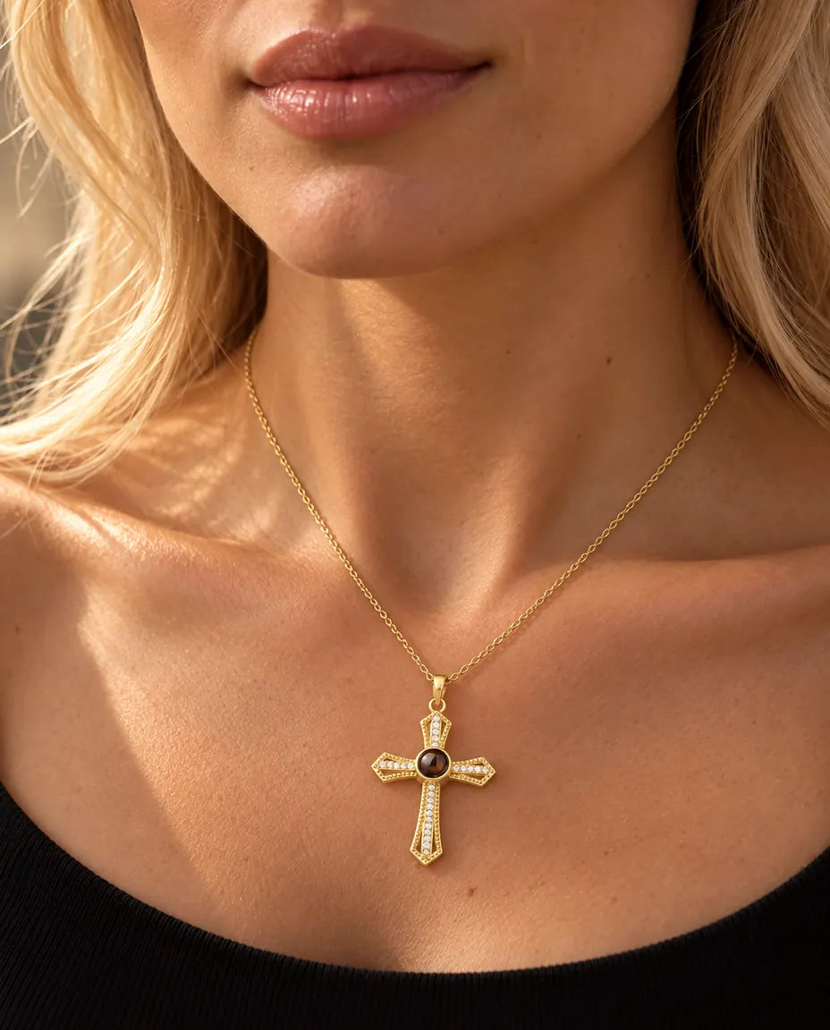 Blonde woman in a black top wearing the gold tone pave cross photo projection necklace