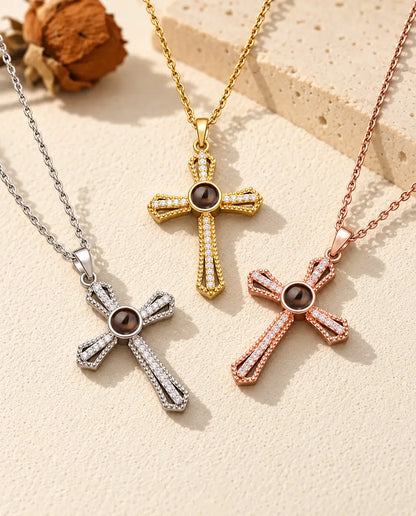 Three colours of the pave cross photo necklace laid out on cream plaster
