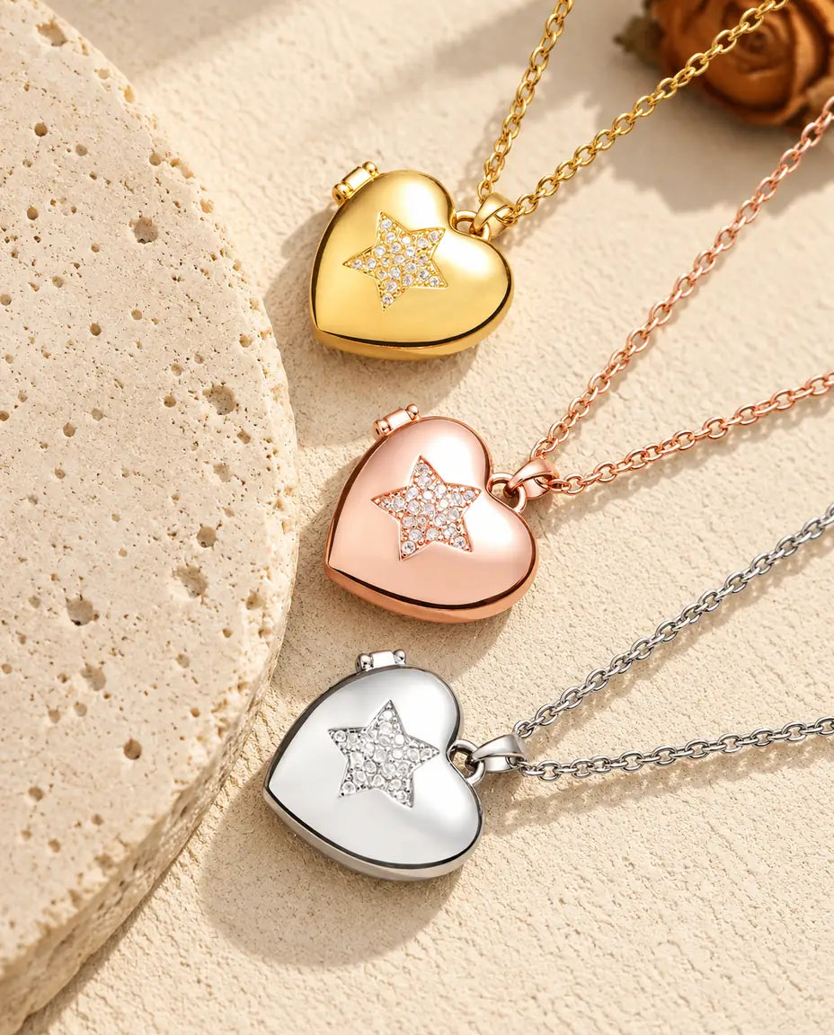 Gold tone, rose gold tone and silver tone pave star heart photo lockets stacked beside a travertine slab