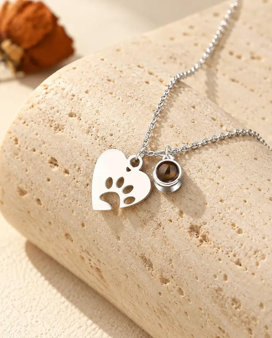 Personalised pet photo projection necklace in silver tone with a paw print heart and a tiny projection stone charm