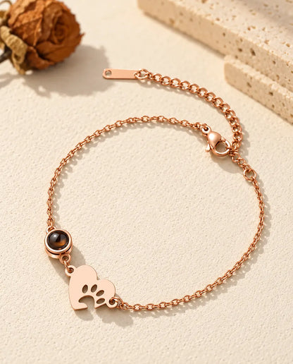 Rose gold tone paw print heart bracelet with a round projection stone and lobster clasp