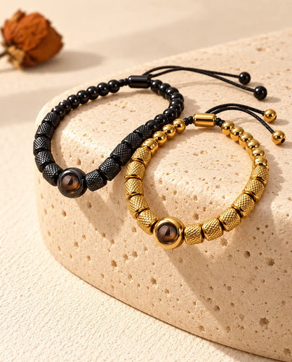 Black and gold tone couples bead bracelets draped over a travertine block