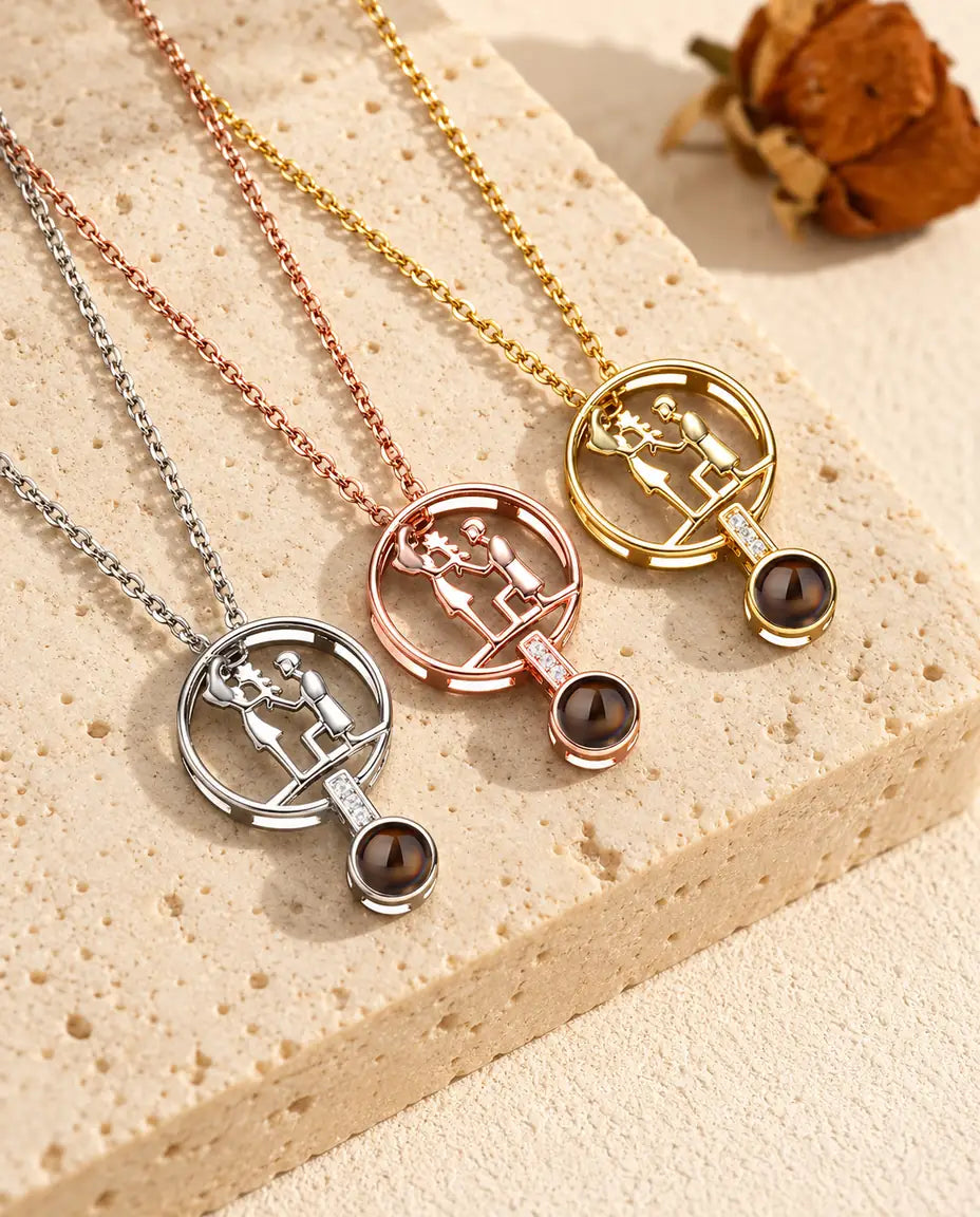 Silver tone, rose gold tone and gold tone kneeling couple pendants laid diagonally