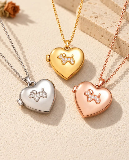 Three colours of the puppy heart photo locket necklace arranged on plaster