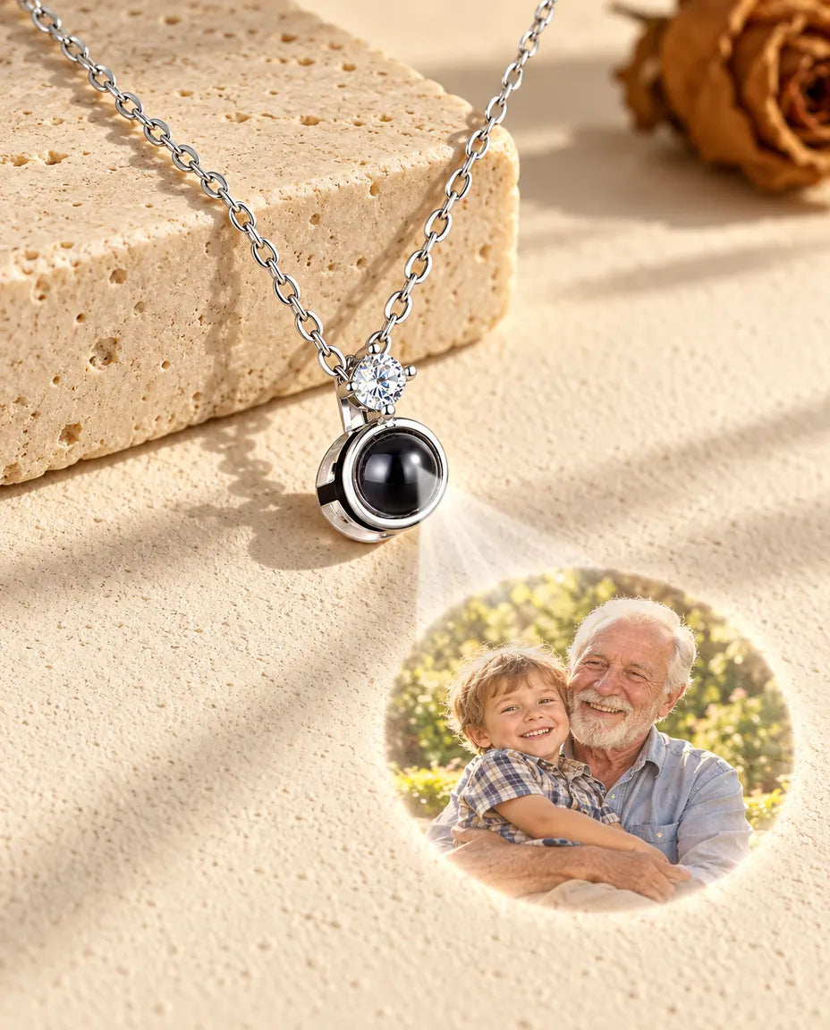 Silver tone solitaire necklace projecting a grandfather and grandson photo onto plaster
