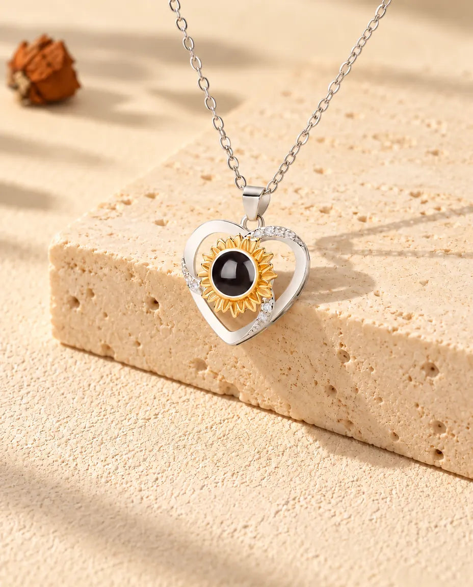 Sunflower heart photo projection necklace draped over a travertine block