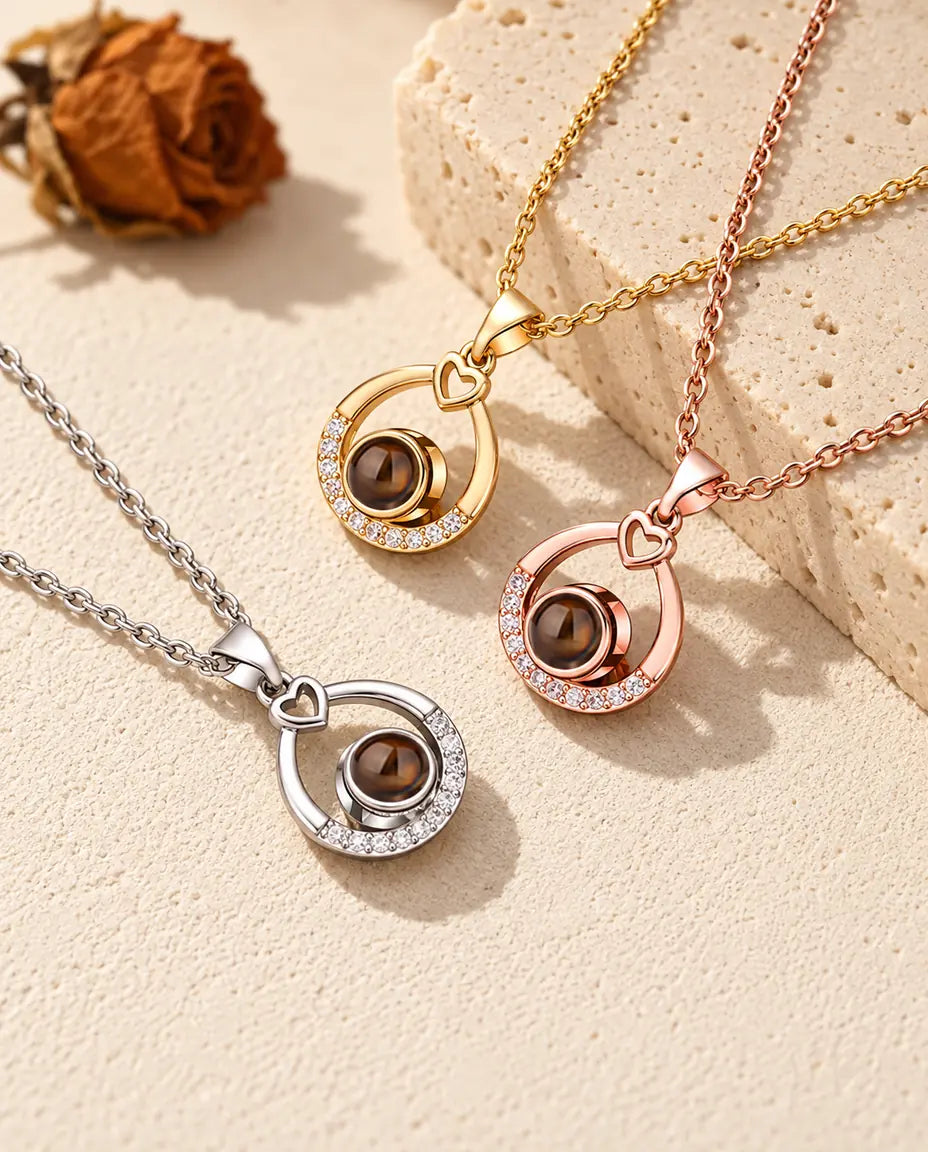 Teardrop projection necklaces in silver tone, gold tone and rose gold tone on travertine