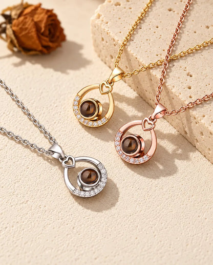 Teardrop projection necklaces in silver tone, gold tone and rose gold tone on travertine