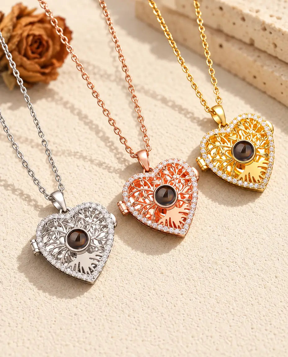 Three colours of the tree of life heart projection locket necklace side by side