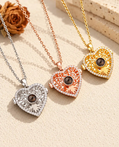Three colours of the tree of life heart projection locket necklace side by side