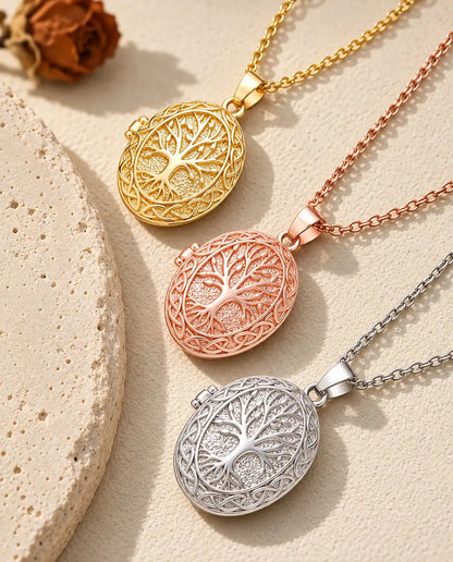 Gold tone, rose gold tone and silver tone tree of life lockets stacked beside a travertine slab