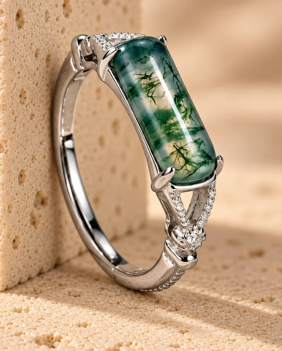 East-West Rectangular Moss Agate Ring - displayed on a travertine block
