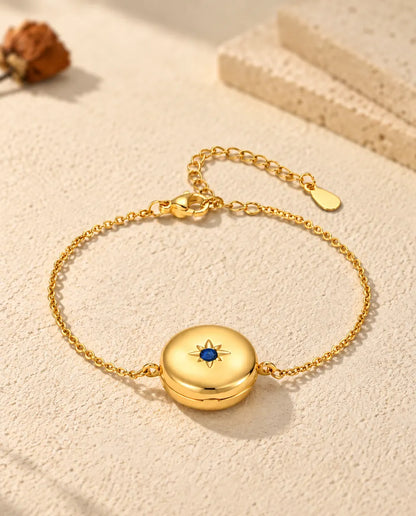 Personalised gold-tone round photo locket bracelet with a birthstone set in a star on the front