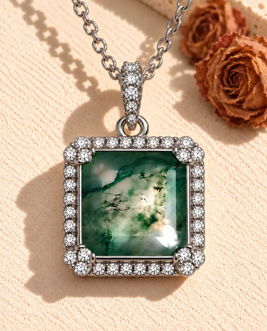 Square Moss Agate Halo Necklace in 925 Sterling Silver - lying on a cream textured surface beside a travertine block