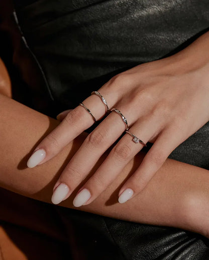 Wavy Moissanite Band Ring in 925 Sterling Silver - worn together with other rings, hands resting on each other